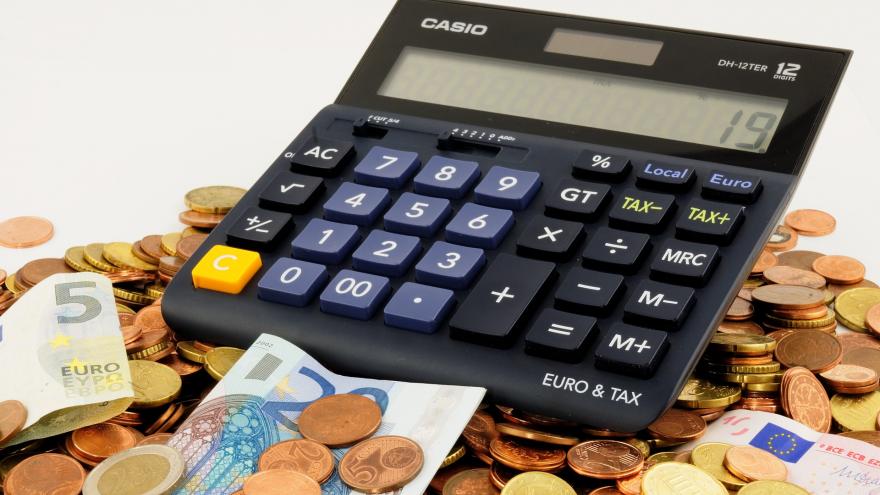 Imagen de una calculadora, varias monedas y billetes
