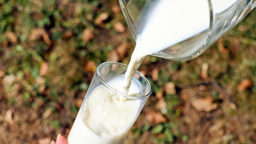 Se está rellenando un vaso de leche desde una jarra