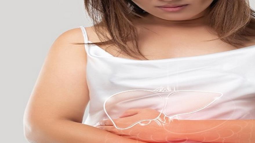 Mujer sujetándose el estómago con gesto de dolor y con dibujo sobreimpreso del hígado e intestino