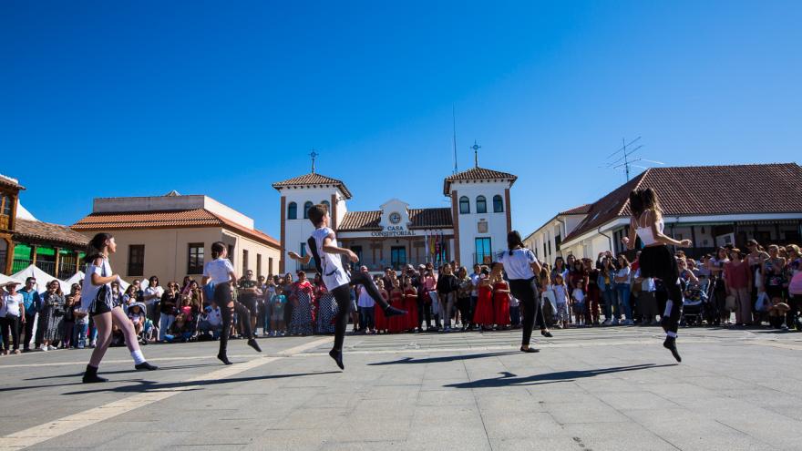 Plaza de pinto con Ayuntamiento y jóvenes bailando