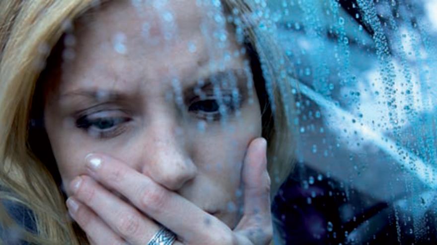 foto de una mujer con mirada triste en un día lluvioso