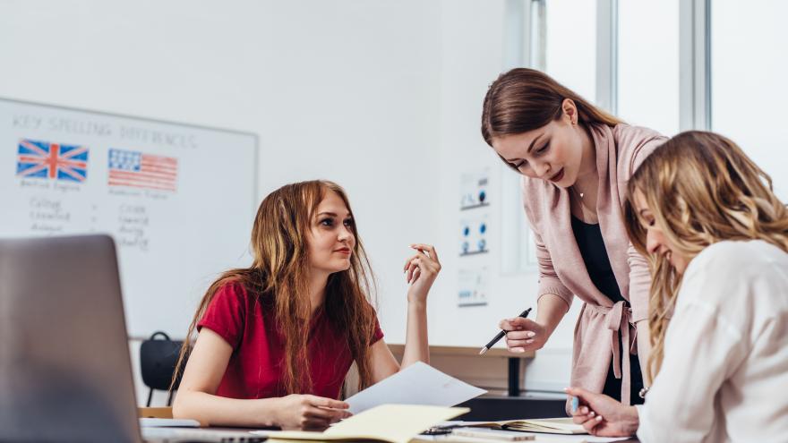 Tres chicas jóvenes sentadas estudiando inglés