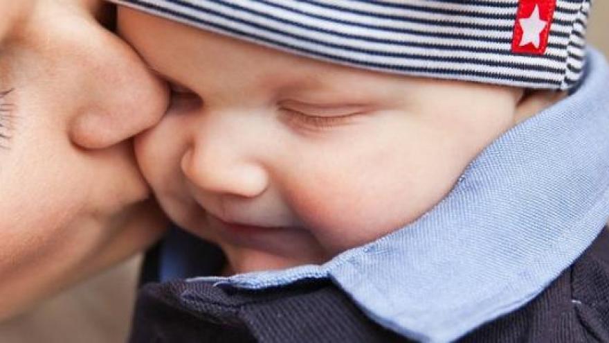 Las caras de una madre besando en la mejilla a su hijo sonriente