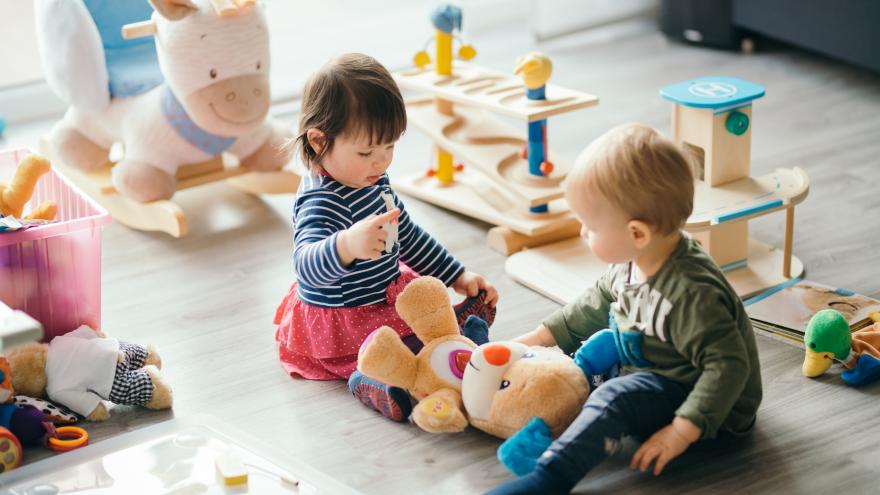 Un niño y una niña jugando en el suelo