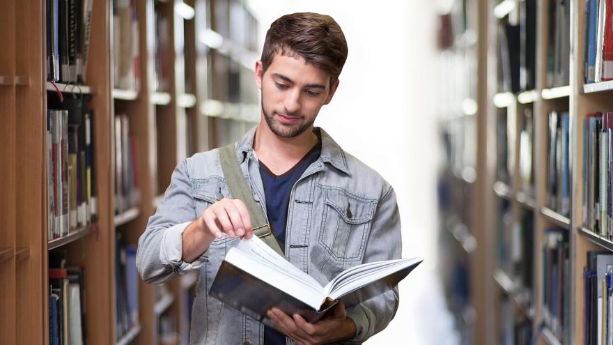 Joven con un libro abierto en la mano