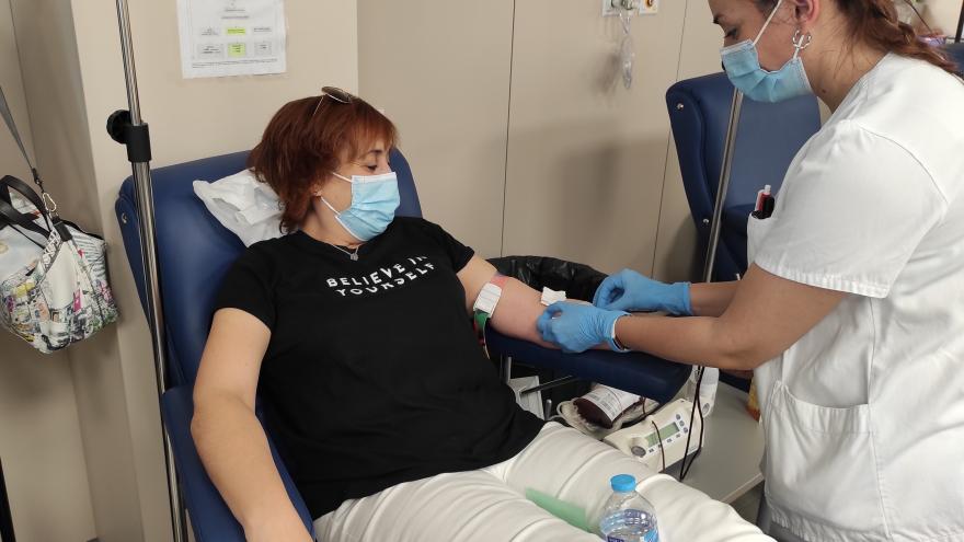 Una persona dona sangre junto a una sanitaria