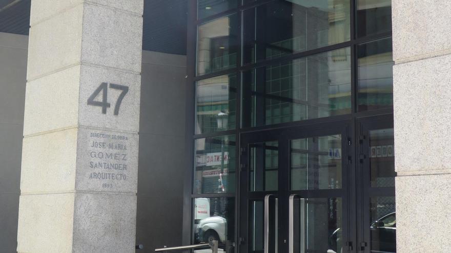 puerta de entrada al edificio de la sede central del IMIDRA en la calle Leganitos nº 47 de Madrid, puerta metálica con listones negros con espejos