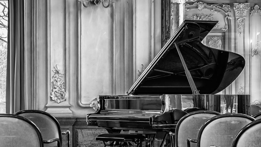 Sala de conciertos vacía con piano en escenario