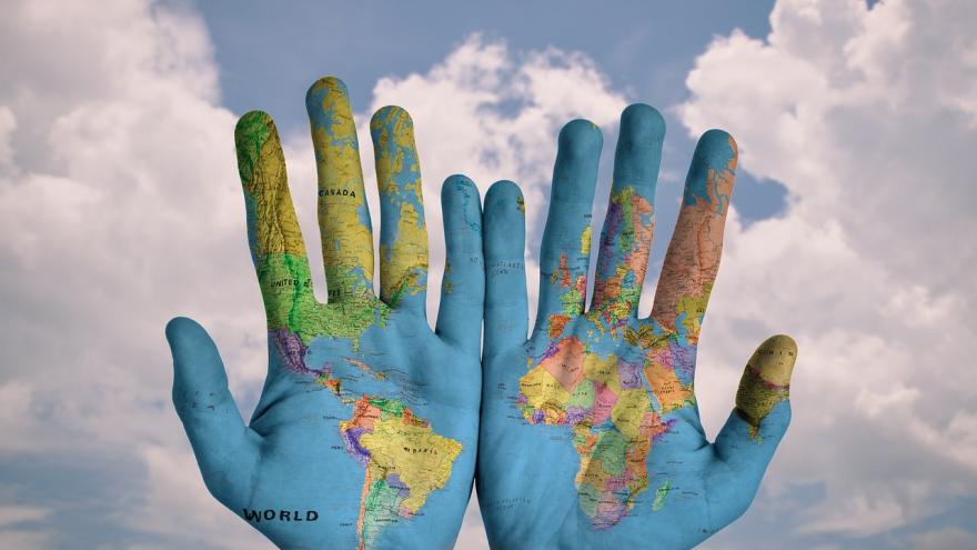 Palmas de las manos con un mapa del mundo pintadas