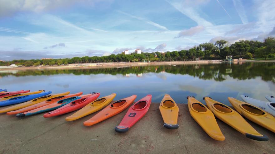Piraguas de varios colores al borde de un lago