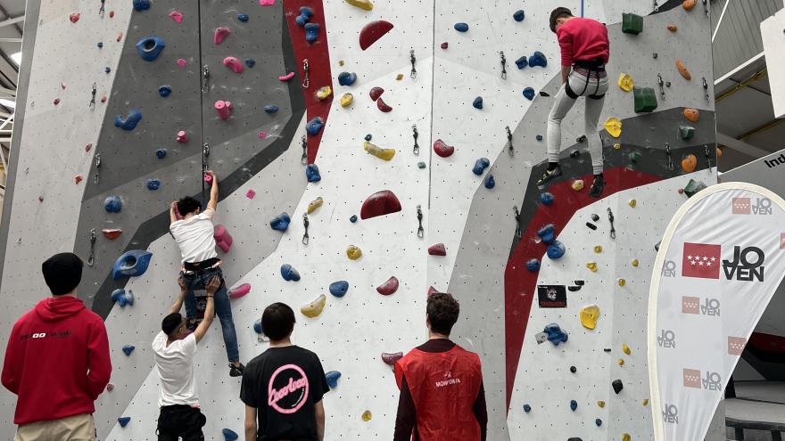 Jóvenes escalando en un rocódromo interior