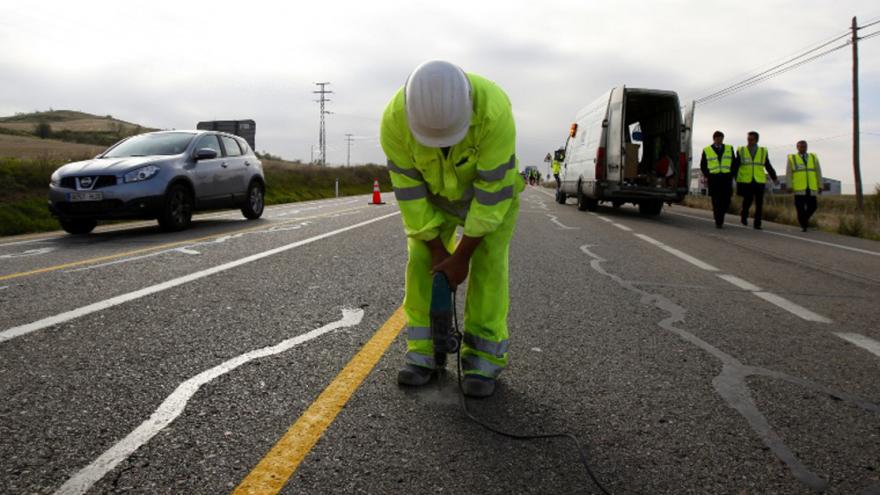 Obreros trabajando en una carretera arreglando el firme