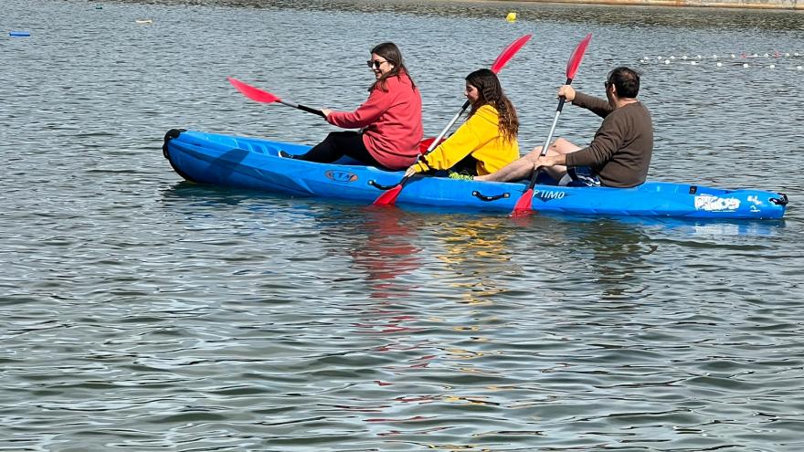 Tres jóvenes remando en una piragua