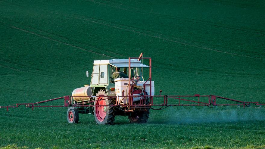 Tractor con aplicador de pesticidas en un campo verde