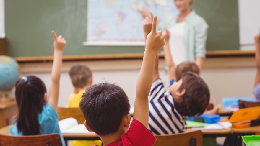 Unos niños levantan la mano durante una clase