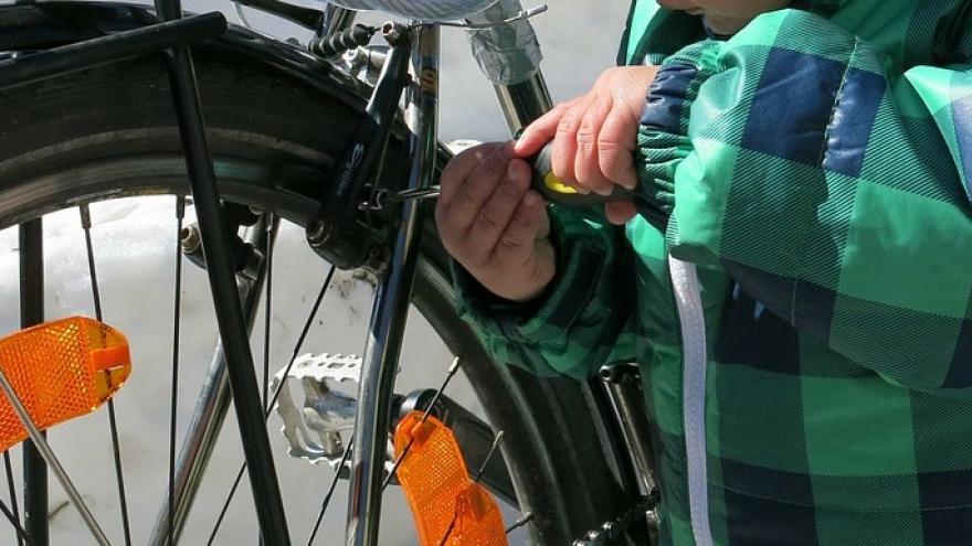 Manos de niño reparar bicicleta