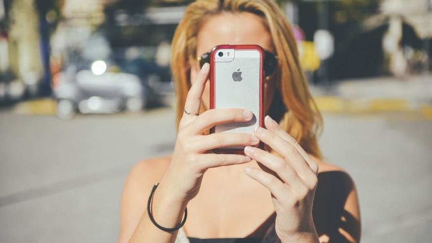 Chica con un móvil en alto tapándole la cara