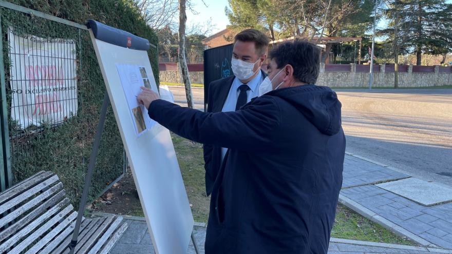 El viceconsejero hablando con el alcalde que le muestra algo en un mural