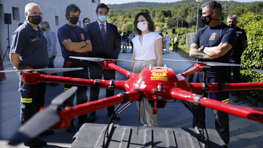 The president with some firefighters looking at a drone