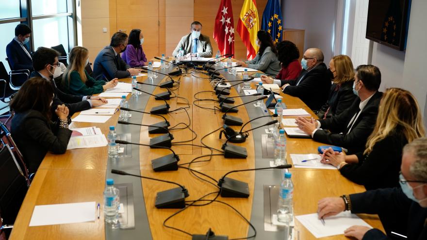 Plano general de la mesa de la reunión con el consejero en la cabecera