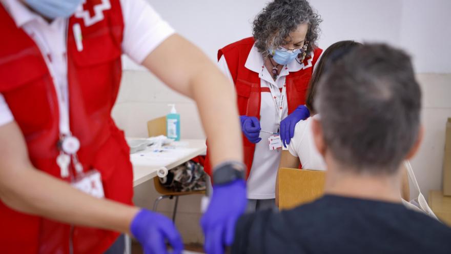 Personal de Cruz Roja poniendo una vacuna