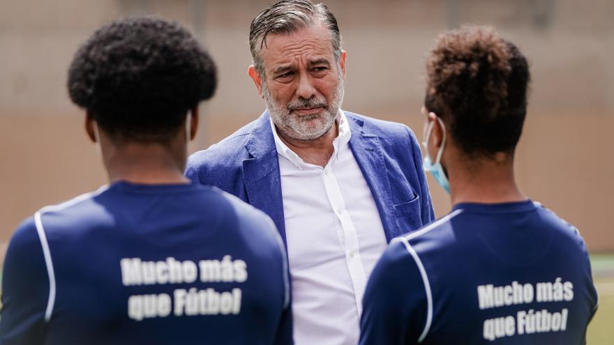 Enrique López talks with two young people
