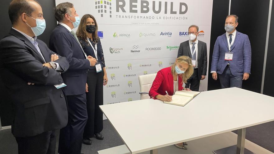 La consejera firmando el libro de visitas del evento