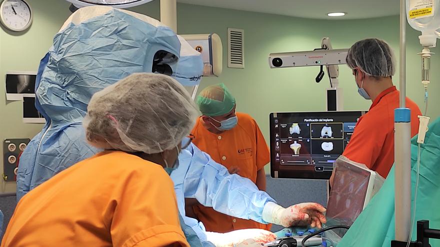 Cirujanos en una operación frente a una pantalla