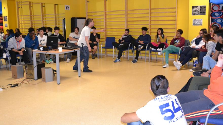 Profesor en movimiento con grupo alumnos sentados