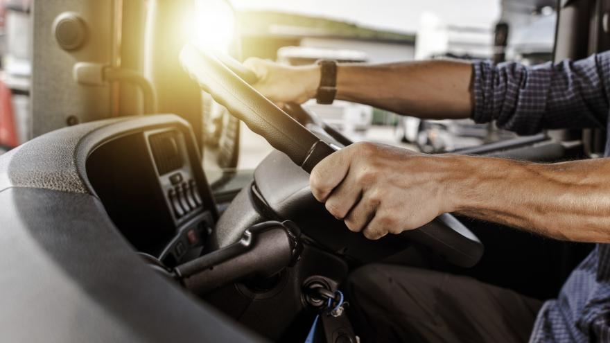 Manos de hombre en volante conduciendo vehiculo industrial