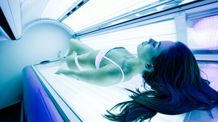 Imagen de una chica en una cámara de bronceado artificial