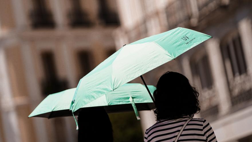 Dos personas con paraguas por la calle 