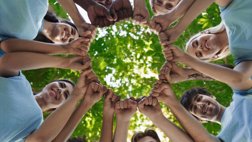 Manos de jóvenes unidas en círculo