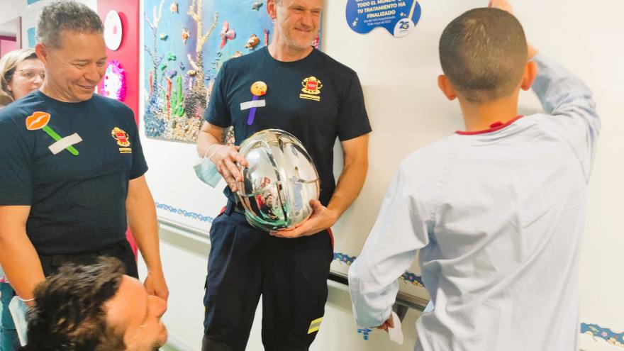 UN niño en el hospital junto a bomberos