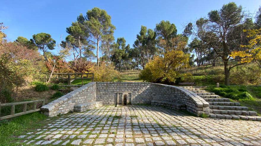 Fuente con un suelo, muro y escalera empedrados