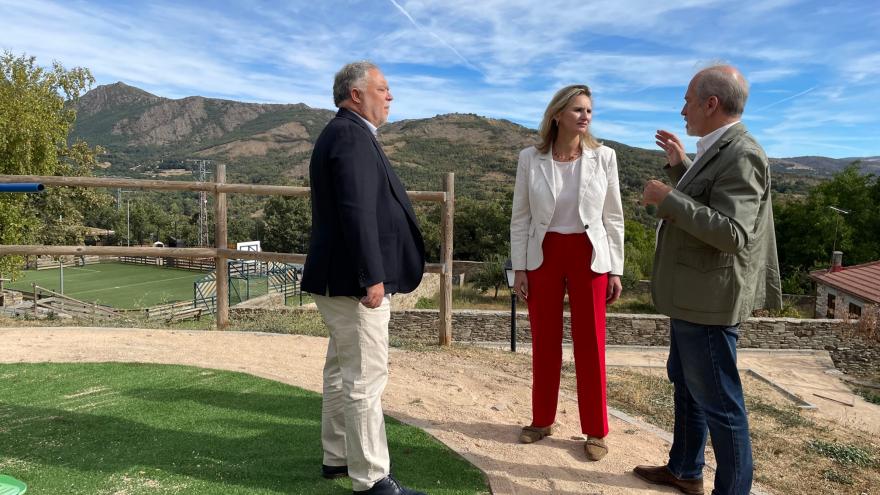 La consejera Paloma Martín con dos personas en un descampado de la Sierra Norte