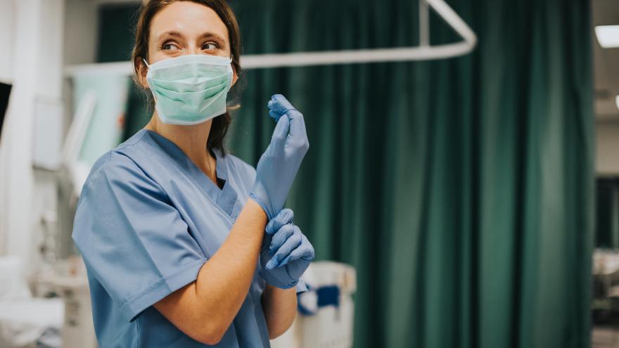 Una enfermera se pone los guantes quirúrgicos
