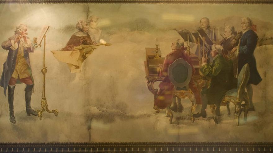 Pintura que representa un grupo de músicos tocando flauta, violín y piano 