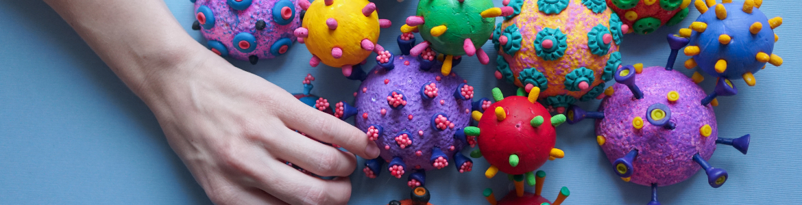 Covid virus del covid en modelos 3D de colores al lado de una mano