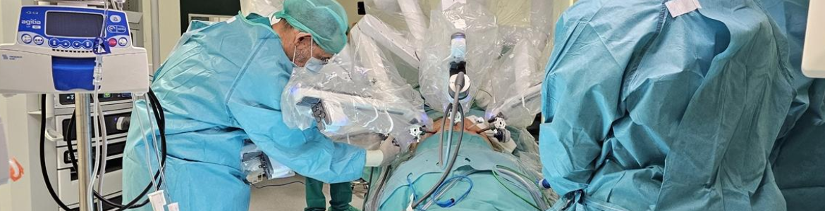 Cirugía robótica Hosptial 12 de Octubre cirujanos en quirófano con un robot con distintos brazos sobre mesa de operaciones