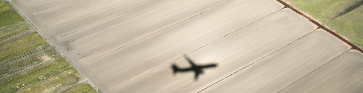 Sombra de un avión sobrevolando un campo