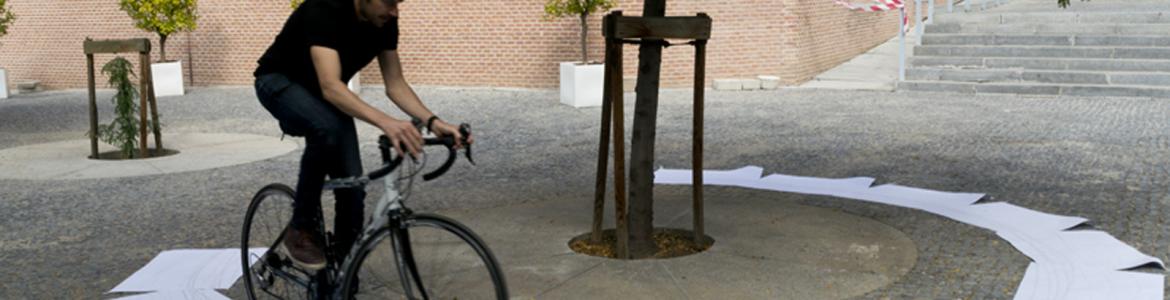 Joven montando en bicicleta sobre un círculo hecho con papeles blancos