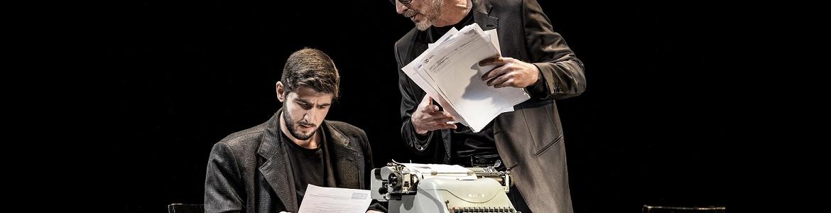 imagen de dos actores en una mesa de escritorio con una máquina de escribir