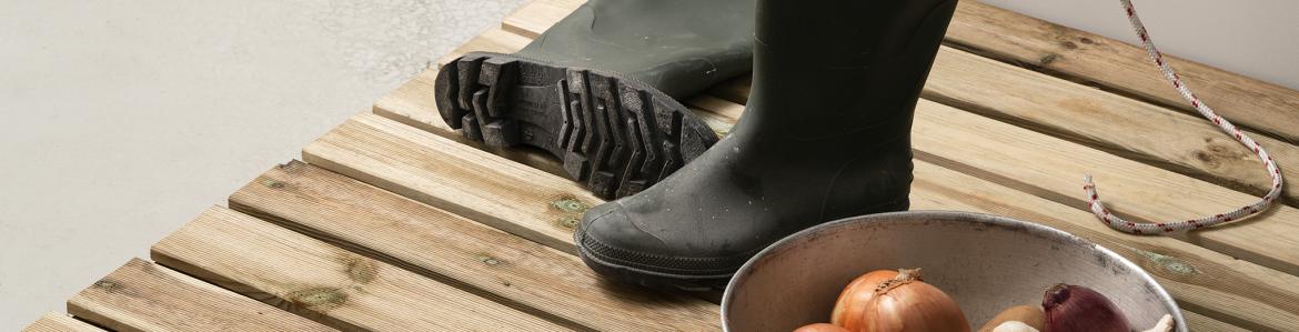 Colectivo PIPOL, Persona 2.0, 2018. Botas de agua y un frutero sobre madera