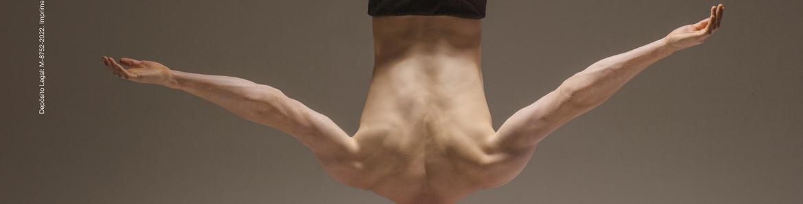 Man doing a headstand surrounded by white juggling balls