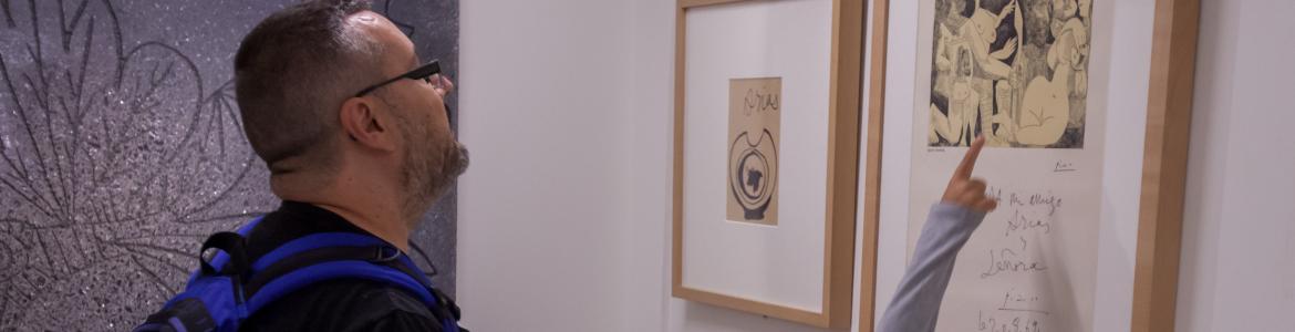 Un hombre y una niña visitando una exposición