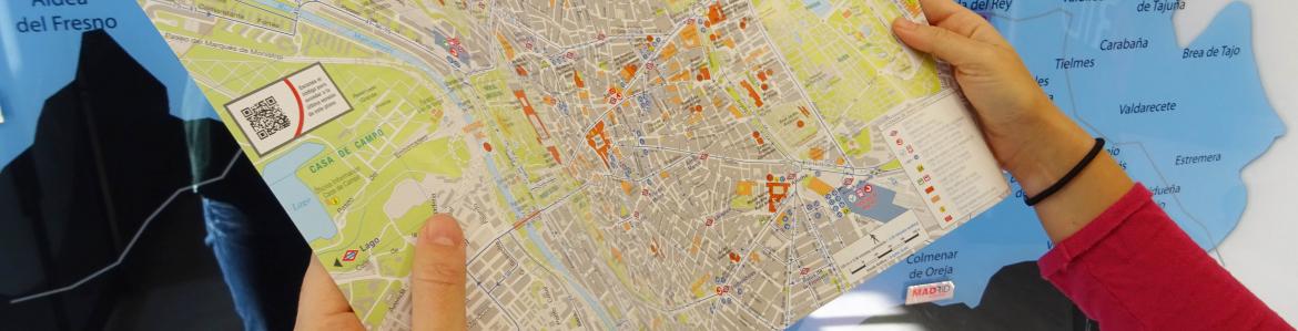 Usuaria de las oficinas de turismo observa un plano de la ciudad de Madrid