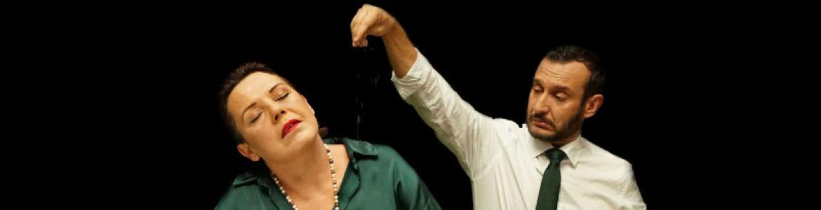 fotografía de un hombre y una mujer delante de una paellera, ella viste vestido verde y él camisa blanca y corbata verde