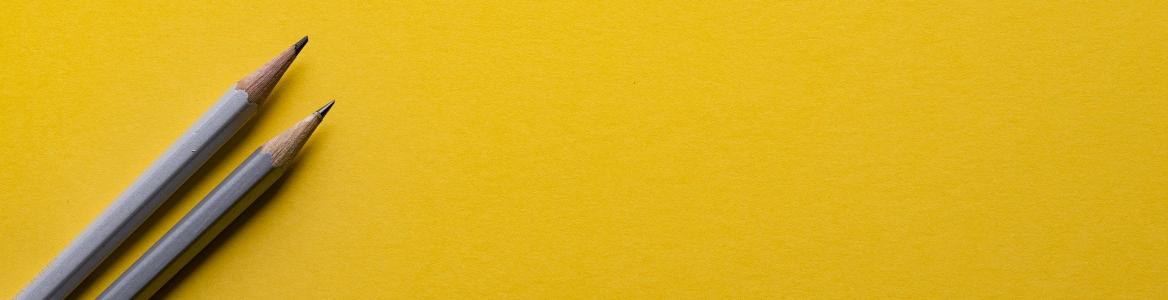 Dos lápices sobre un fondo amarillo