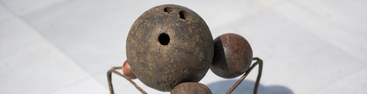 Escultura formada por tres bolas sobre un trébede de hierro